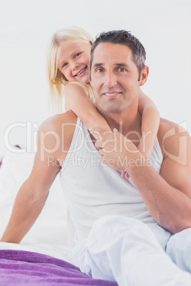 Smiling father and his daughter doing piggy-back