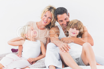 Family posing on a bed