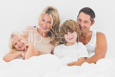 Family lying on a white bed