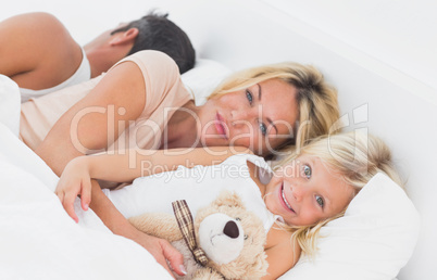 Family lying together on a bed