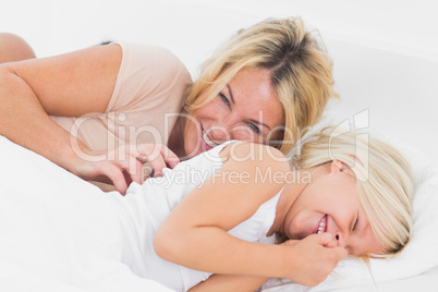 Mother tickling her daughter