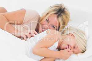 Mother tickling her daughter