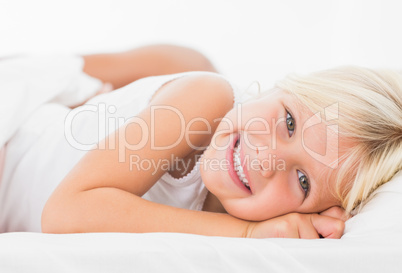 Little girl lying on a bed and smiling