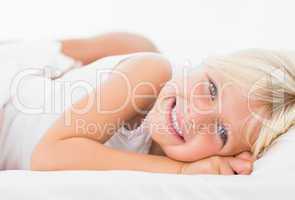 Little girl lying on a bed and smiling