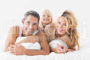 Family posing lying on a bed