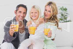 Family holding glasses of orange juice