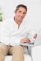 Cheerful man typing on the laptop