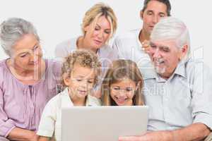 Joyful family watching a laptop screen together