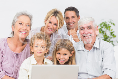 Family smiling in front of a laptop screen