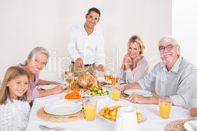 Smiling father cutting slices of turkey