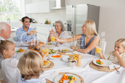 Smiling family raising their glasses together