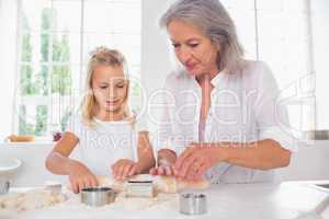 Grandmother and granddaughter making biscuits