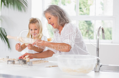 Grandmother and granddaughter using a rolling pin