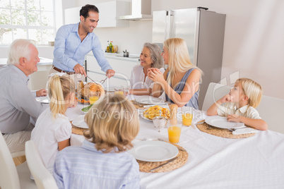 Smiling father proposing a slice of turkey