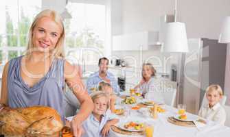 Blonde woman showing the roast turkey