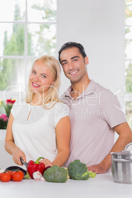 Smiling blonde woman cooking with her husband