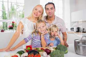 Posing family cutting vegetables