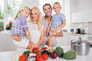 Children in their parents arms in the kitchen