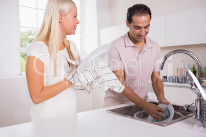 Happy couple washing dishes together