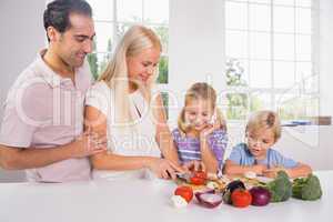 Family cutting vegetables together