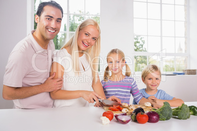 Smiling family cutting vegetables together