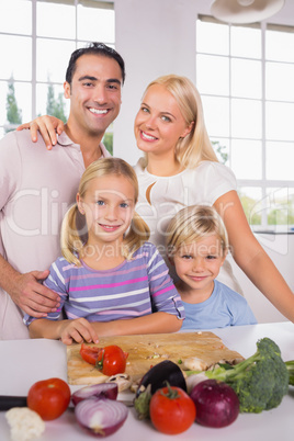 Posing family cutting vegetables together