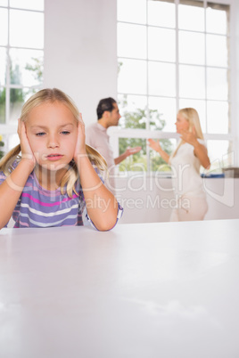 Girl looking despressed in front of fighting parents