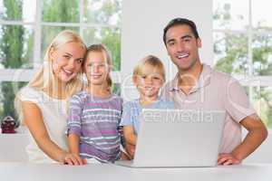 Happy family using a laptop together