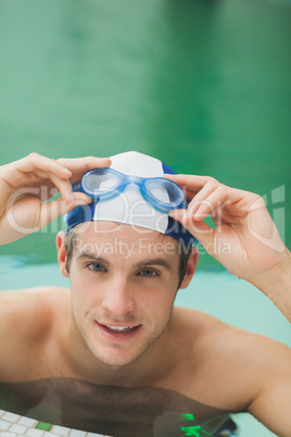 Smiling man taking off goggles