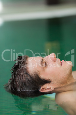 Relaxed man floating in pool