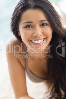 Smiling girl lying by the pool