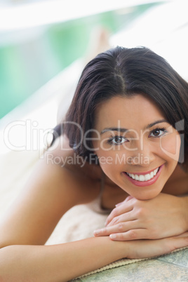 Woman lying on towel by pool