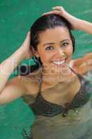 Pretty woman touching her hair in pool