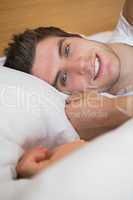 Handsome man smiling in bed