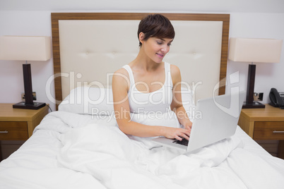 Woman using laptop in bed Woman using laptop in bed