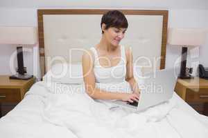 Woman using laptop in bed