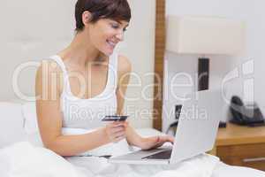 Woman shopping online in bed