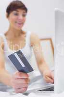 Smiling woman shopping online on bed