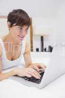 Pretty woman using laptop in bed