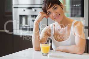 Smiling woman having orange juice