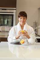 Woman drinking her orange juice at breakfast
