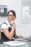 Young female executive with laptop at office desk