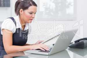 Business woman with paper using laptop at office