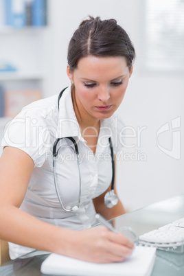 Doctor writing a prescription at desk