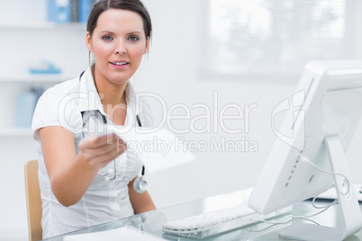 Doctor giving you prescription in front of computer at clinic de