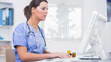 Female surgeon using computer at clinic