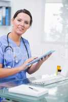 Portrait of female surgeon using digital tablet at clinic