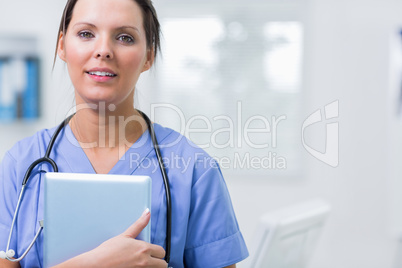 Female surgeon holding digital tablet at clinic