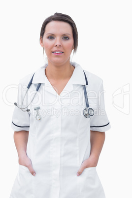 Portrait of smiling nurse standing with hands in pockets