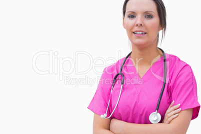 Portrait of smiling nurse standing with arms crossed